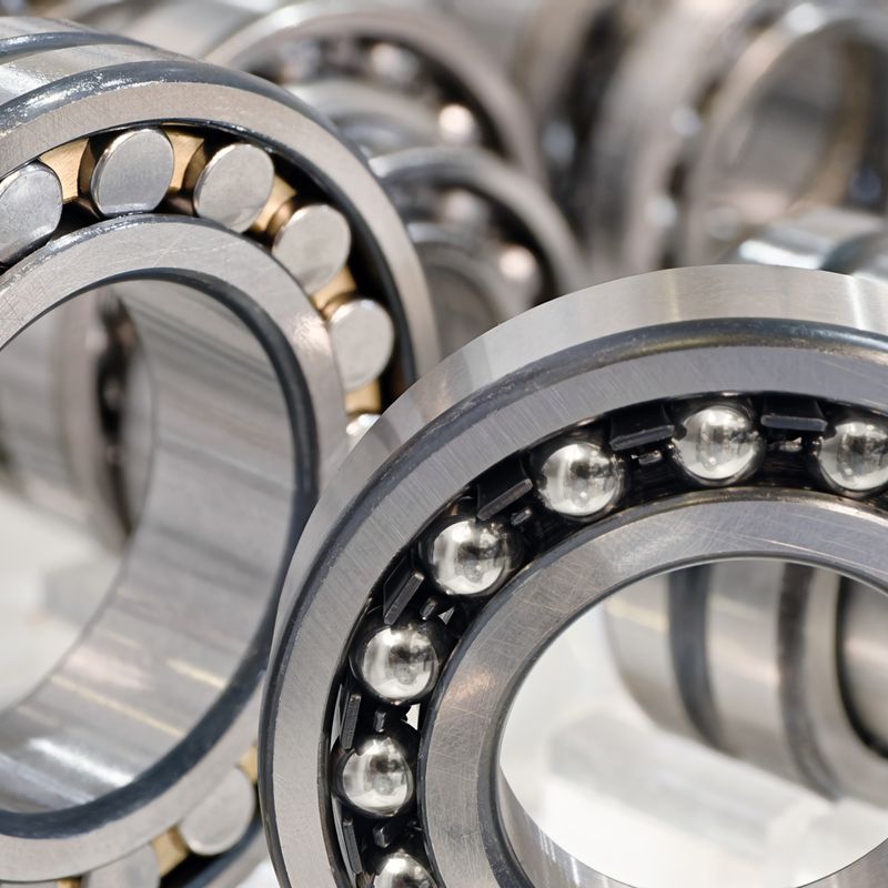 Close-up of multiple ball bearings and roller bearings, showcasing their metallic construction and circular design.
